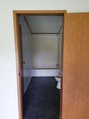 bathroom with toilet and  shower combination