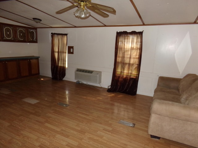 unfurnished living room with wood-type flooring, a wall mounted AC, vaulted ceiling, and ceiling fan