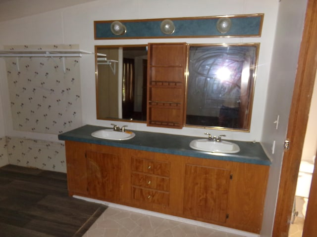 bathroom featuring hardwood / wood-style floors, vaulted ceiling, and vanity