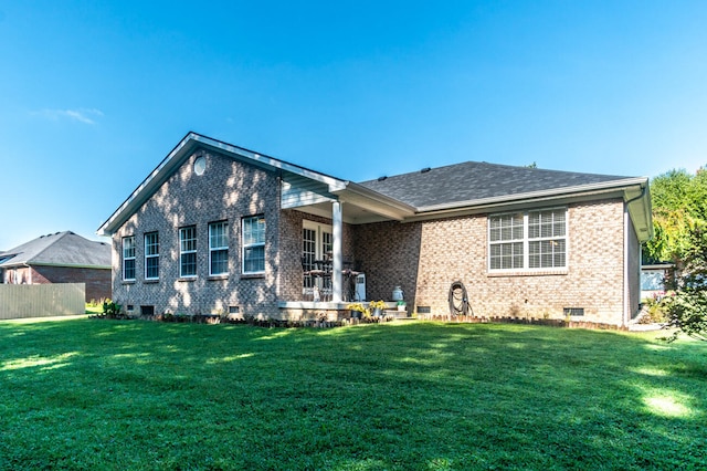 rear view of property featuring a lawn