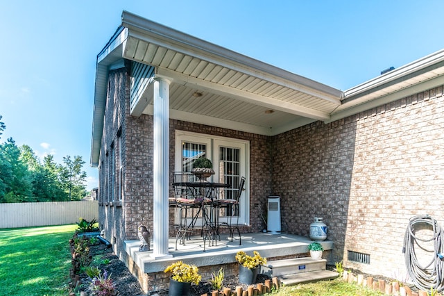 property entrance featuring covered porch and a lawn