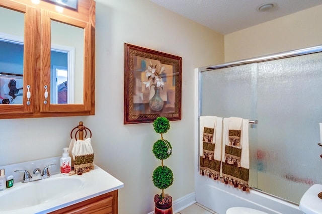 full bathroom featuring combined bath / shower with glass door, vanity, and toilet