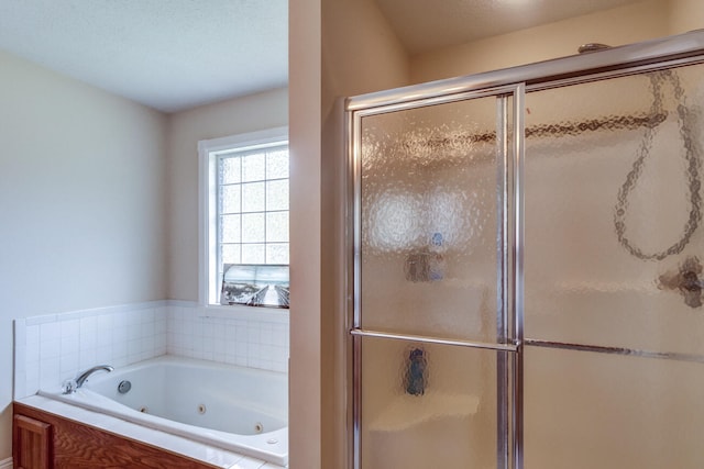 bathroom featuring independent shower and bath and a textured ceiling