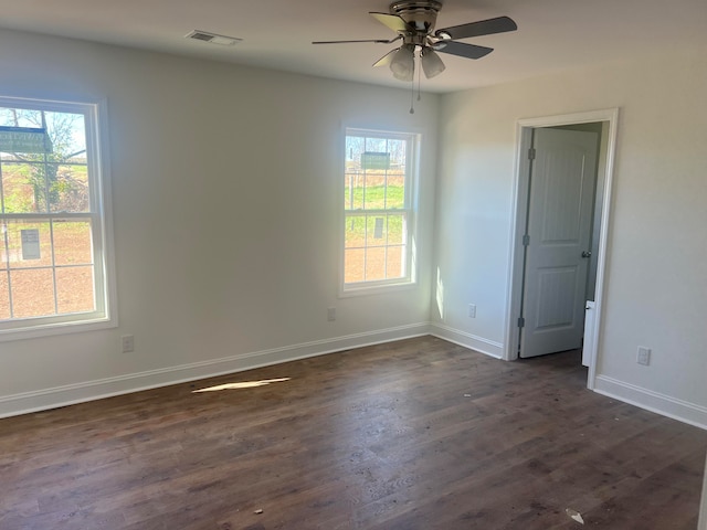 spare room with ceiling fan, dark hardwood / wood-style floors, and a healthy amount of sunlight