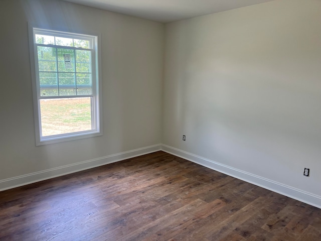 spare room featuring dark hardwood / wood-style flooring and plenty of natural light