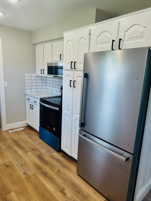 kitchen with light hardwood / wood-style flooring, stainless steel appliances, backsplash, and white cabinetry