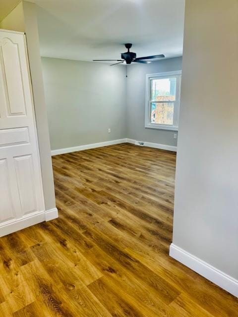 empty room with hardwood / wood-style floors and ceiling fan