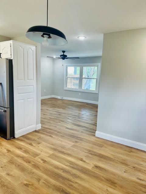 unfurnished dining area with ceiling fan and light hardwood / wood-style floors