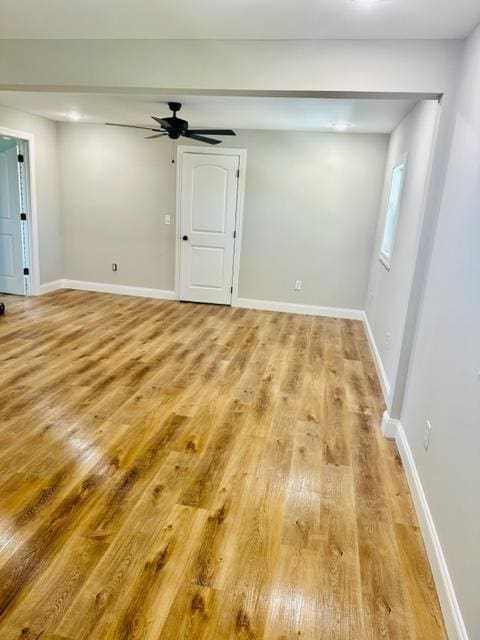 empty room with ceiling fan and light hardwood / wood-style floors