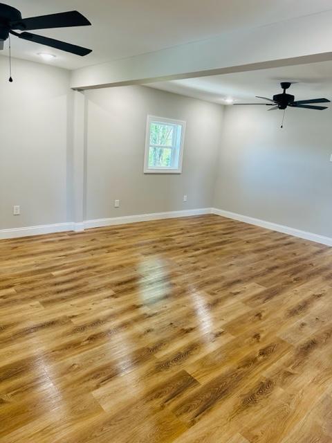 empty room featuring light wood-type flooring and ceiling fan