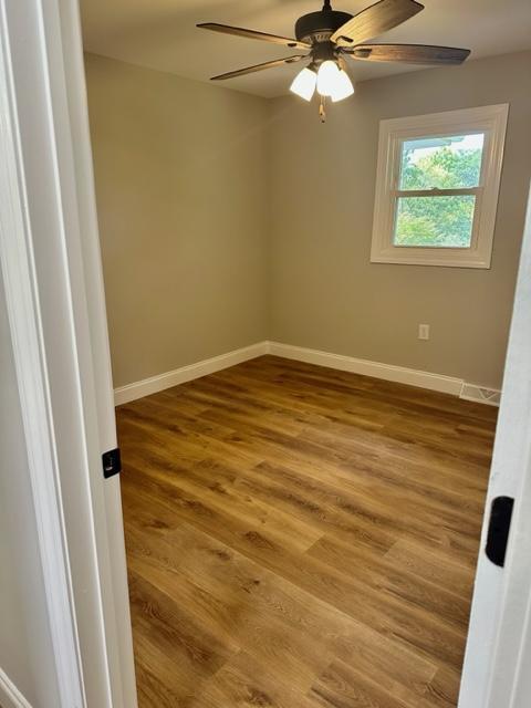 spare room with hardwood / wood-style floors and ceiling fan