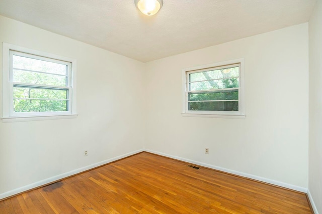 spare room with hardwood / wood-style flooring and a textured ceiling