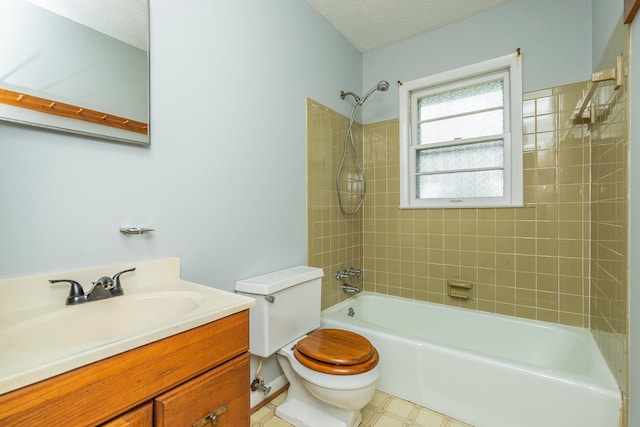 full bathroom with tiled shower / bath, toilet, a textured ceiling, and vanity