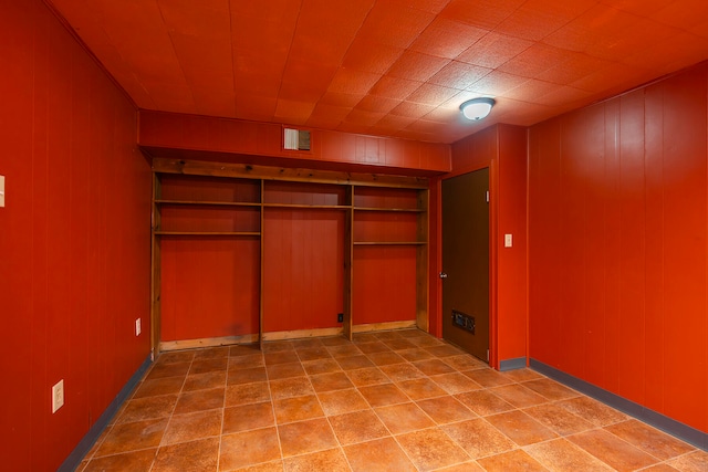 unfurnished bedroom with wood walls and a closet