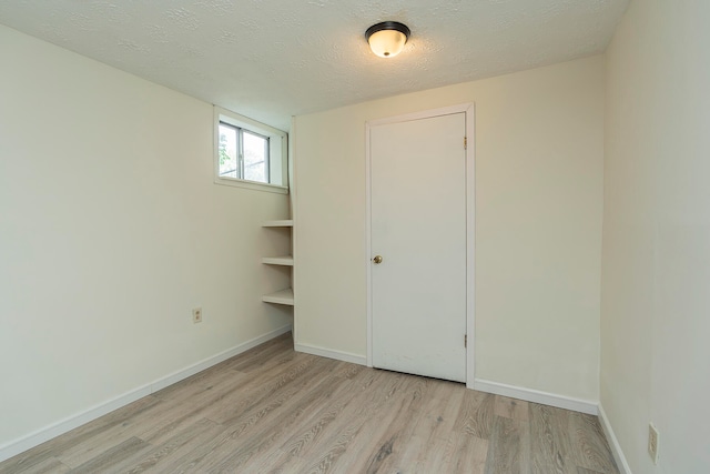 unfurnished bedroom with a textured ceiling and light hardwood / wood-style floors