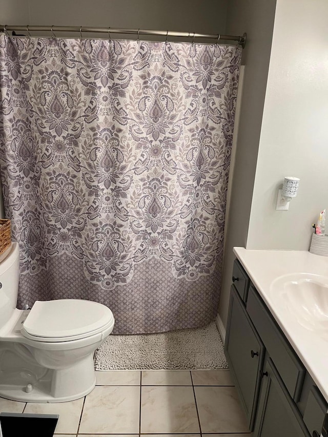 bathroom with vanity, toilet, walk in shower, and tile patterned flooring