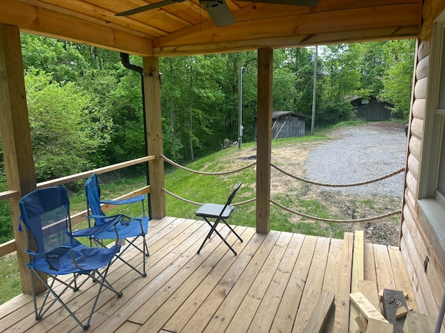 wooden deck with a yard and ceiling fan