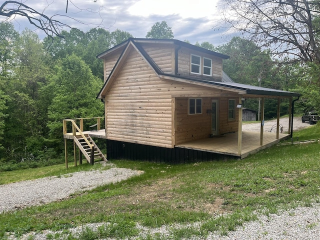 view of side of property with a deck, log veneer siding, and stairs