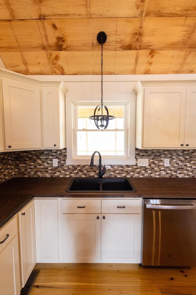 kitchen with stainless steel dishwasher, pendant lighting, white cabinets, and sink