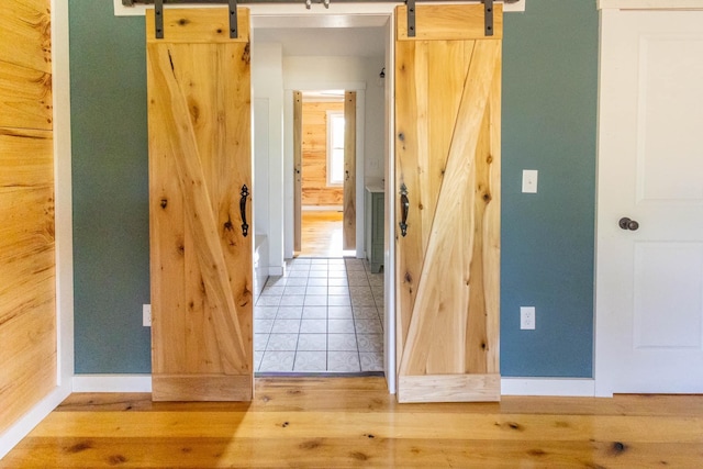 hall with a barn door and hardwood / wood-style flooring