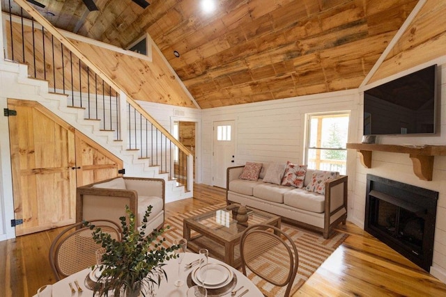 living room with wooden ceiling, wooden walls, light hardwood / wood-style floors, and lofted ceiling