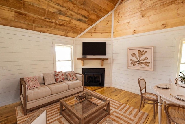 living room featuring wood-type flooring, vaulted ceiling, wooden ceiling, and wood walls