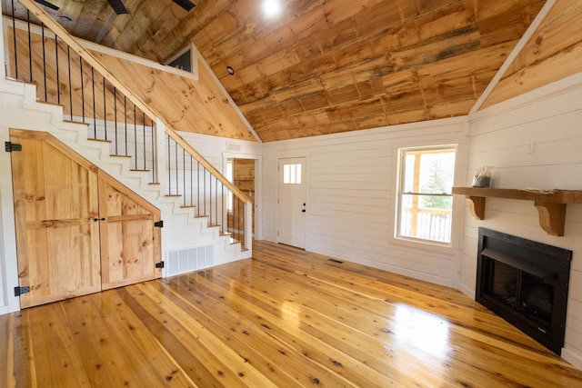 unfurnished living room with wood walls, wood-type flooring, wood ceiling, and vaulted ceiling