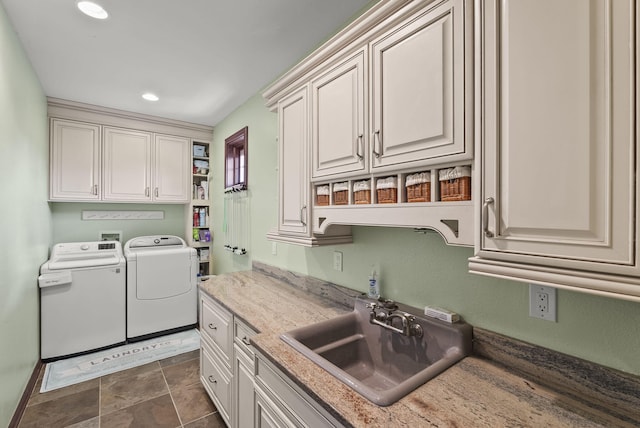 kitchen with light stone countertops, washer and dryer, and sink