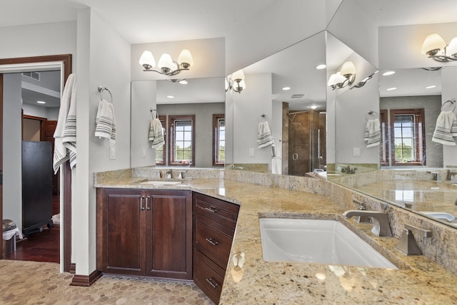 kitchen featuring light wood-type flooring, light stone countertops, a wealth of natural light, and sink