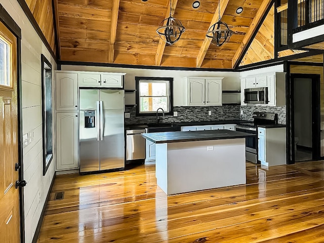 kitchen with wooden ceiling, light hardwood / wood-style flooring, a kitchen island, white cabinetry, and stainless steel appliances