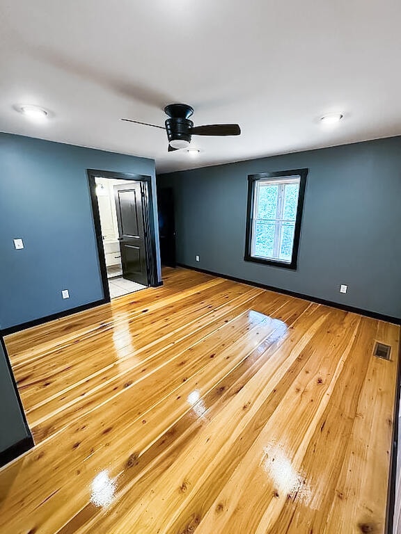 unfurnished bedroom with ceiling fan and light wood-type flooring