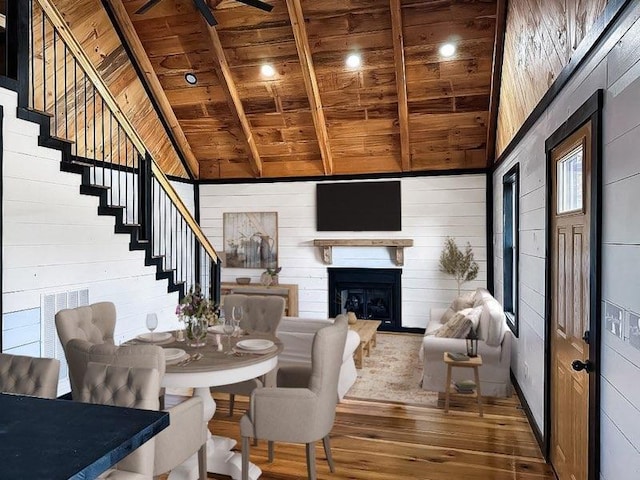 dining area featuring wooden walls, high vaulted ceiling, wooden ceiling, beamed ceiling, and dark hardwood / wood-style floors