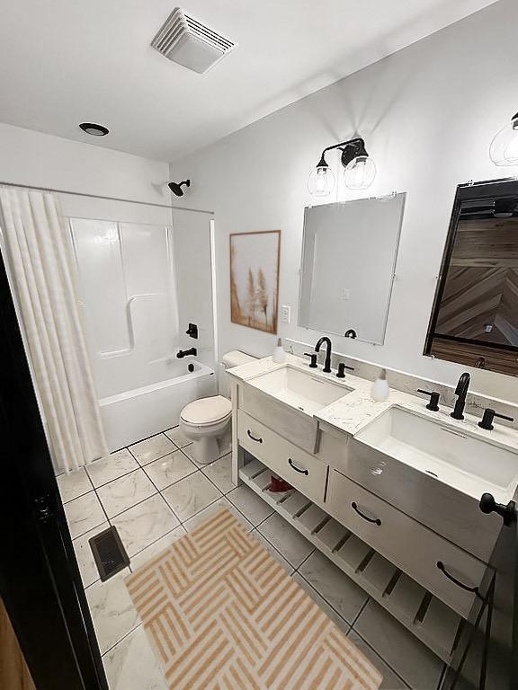 full bathroom with tile patterned floors, toilet, vanity, and washtub / shower combination