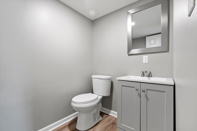 bathroom with vanity, toilet, and wood-type flooring