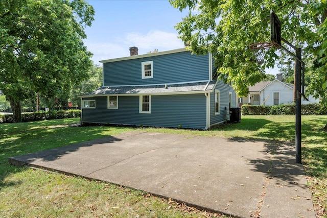 back of property with cooling unit and a lawn