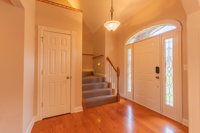 entryway with vaulted ceiling and light hardwood / wood-style floors