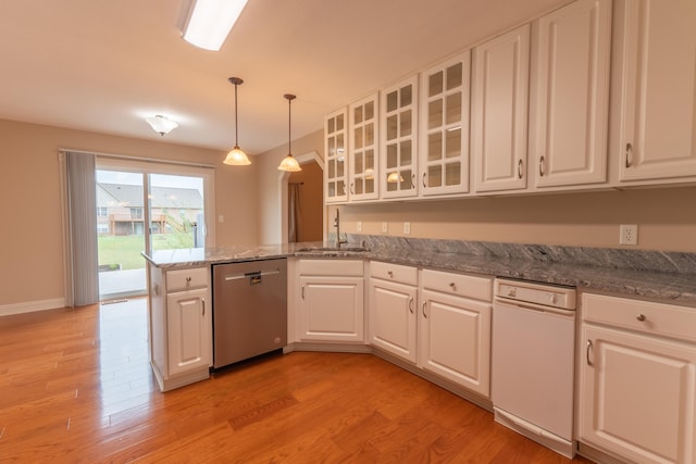 kitchen with light wood-type flooring, dishwasher, sink, and white cabinets