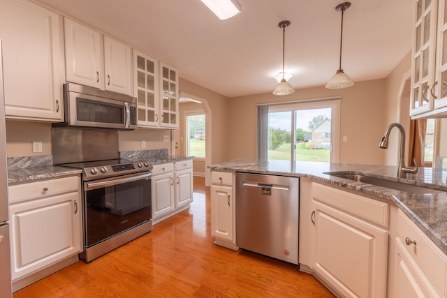 kitchen featuring appliances with stainless steel finishes, light wood-type flooring, and white cabinetry