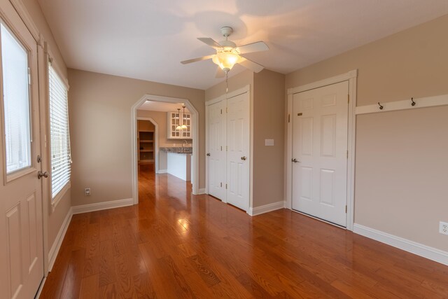 unfurnished bedroom with wood-type flooring, sink, and ceiling fan