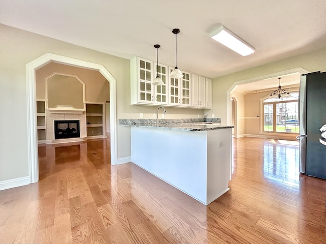 244 Water Cliff Dr, Somerset, KY 42503 - unfurnished living room with a tiled fireplace, light wood finished floors, baseboards, and a healthy amount of sunlight