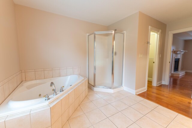 bathroom featuring wood-type flooring and plus walk in shower