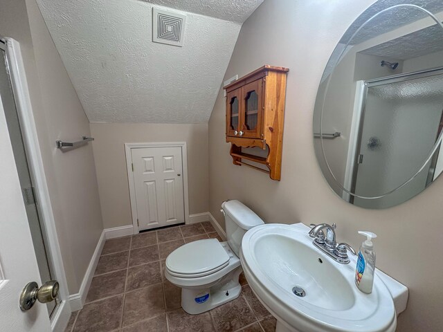 bathroom featuring lofted ceiling, sink, an enclosed shower, a textured ceiling, and toilet