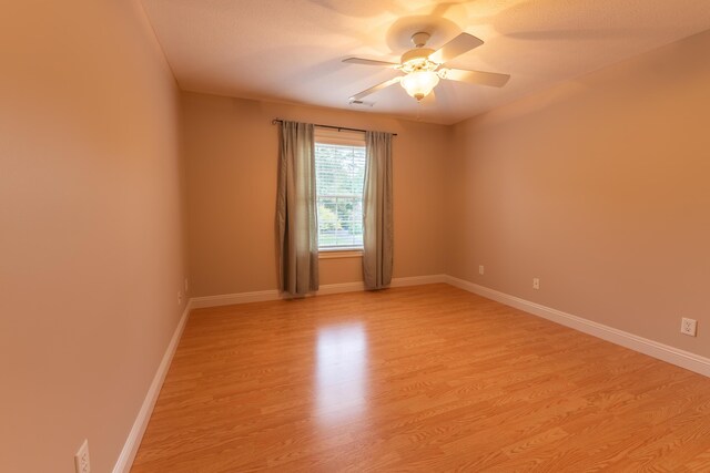 empty room featuring ceiling fan and light hardwood / wood-style floors