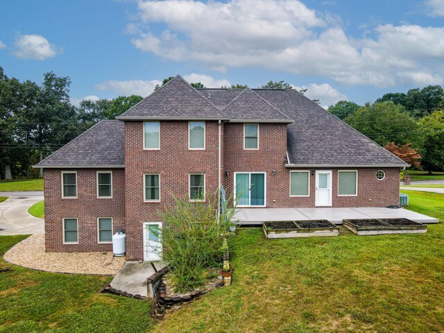 back of property with central AC and a yard