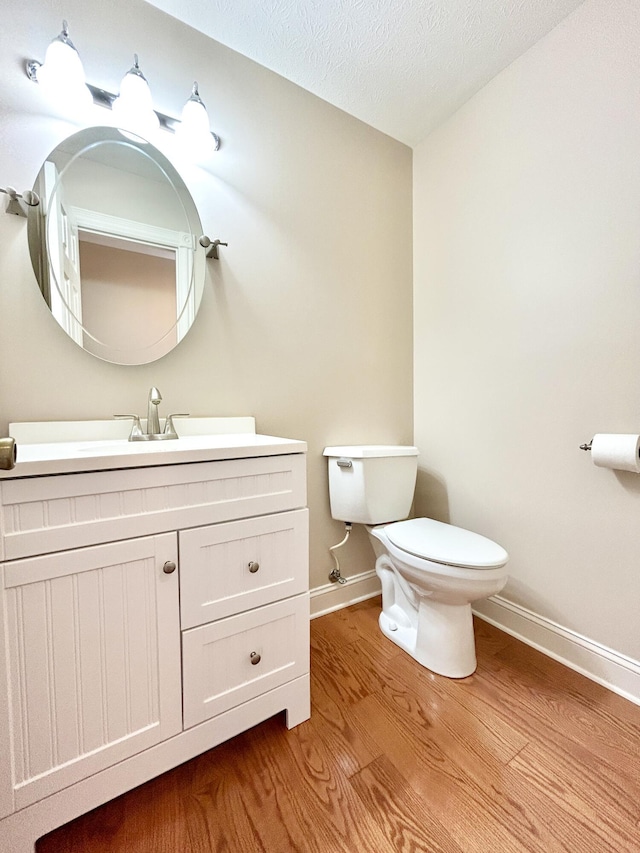 244 Water Cliff Dr, Somerset, KY 42503 - half bathroom with a textured ceiling, vanity, toilet, wood finished floors, and baseboards