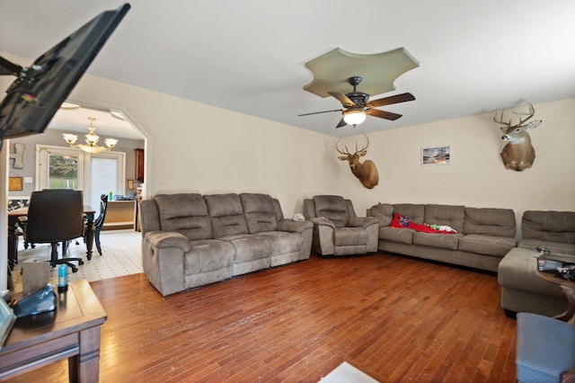 living room featuring ceiling fan with notable chandelier and hardwood / wood-style flooring