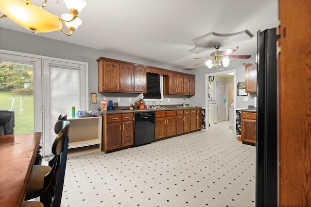 kitchen featuring dishwasher, a chandelier, a ceiling fan, dark countertops, and a sink