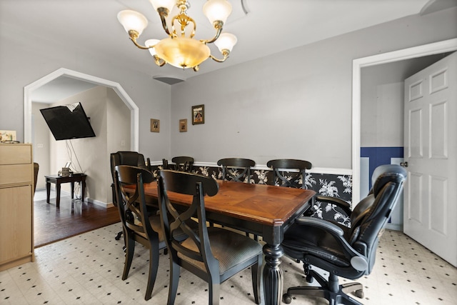 dining area featuring light wood-type flooring and a notable chandelier