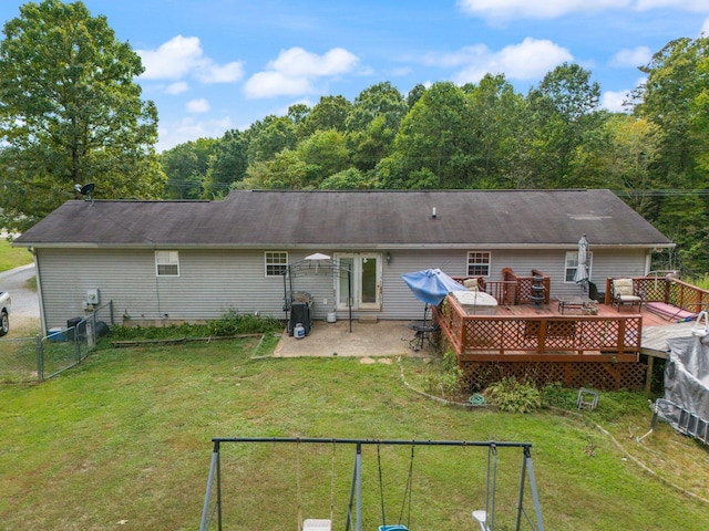 rear view of property featuring a wooden deck, a patio area, and a view of trees