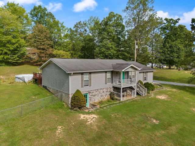 view of front of property with a deck and a front lawn